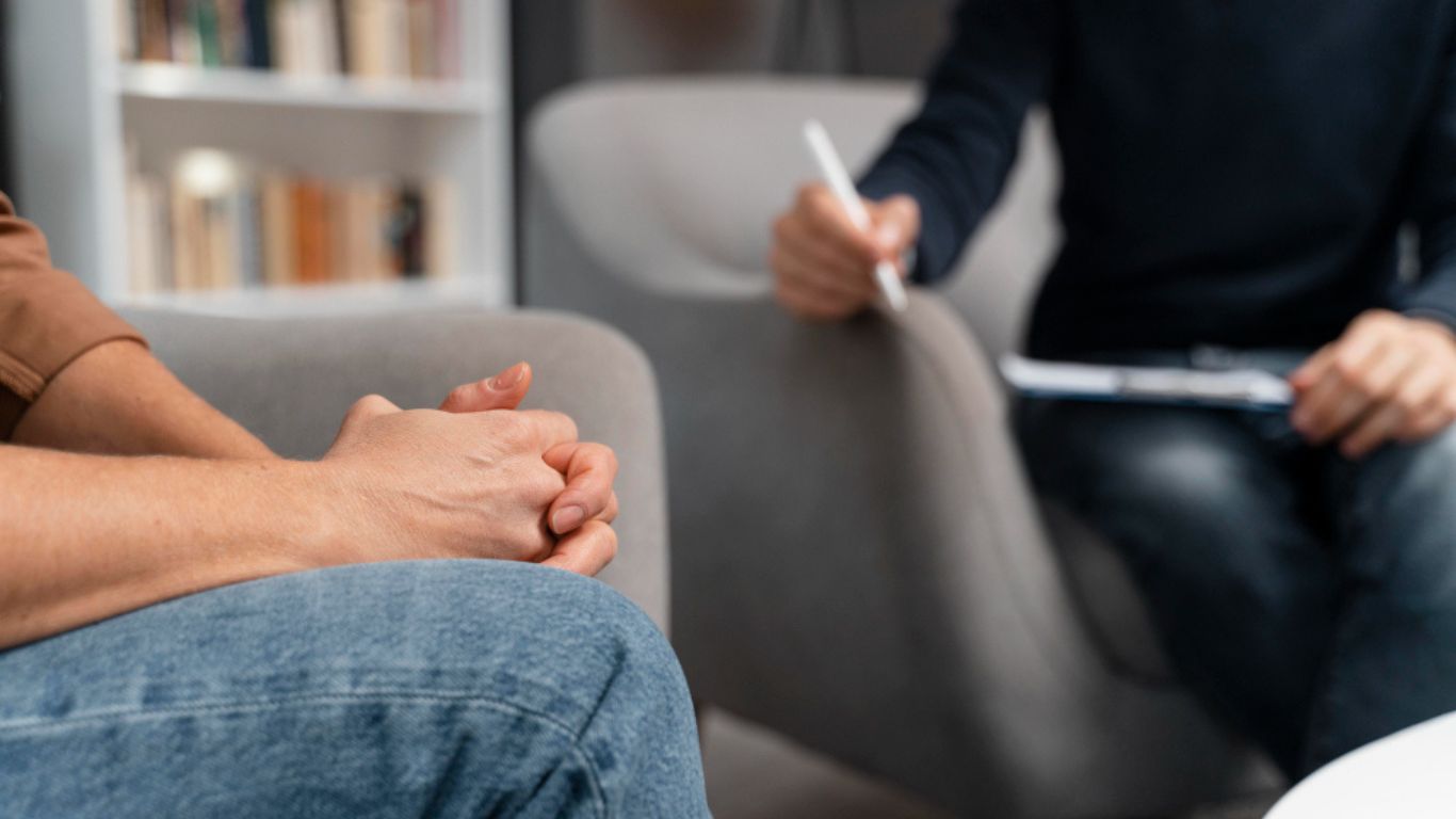 Person with alcohol and drugs on a table